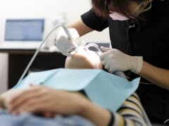 歯の表面のクリーニングをしてもらっている女性