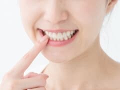 歯を押さえる女性