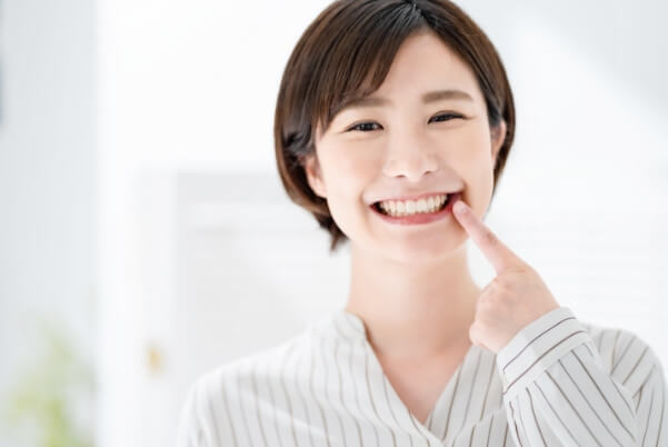 白い歯を見せる笑顔の女性